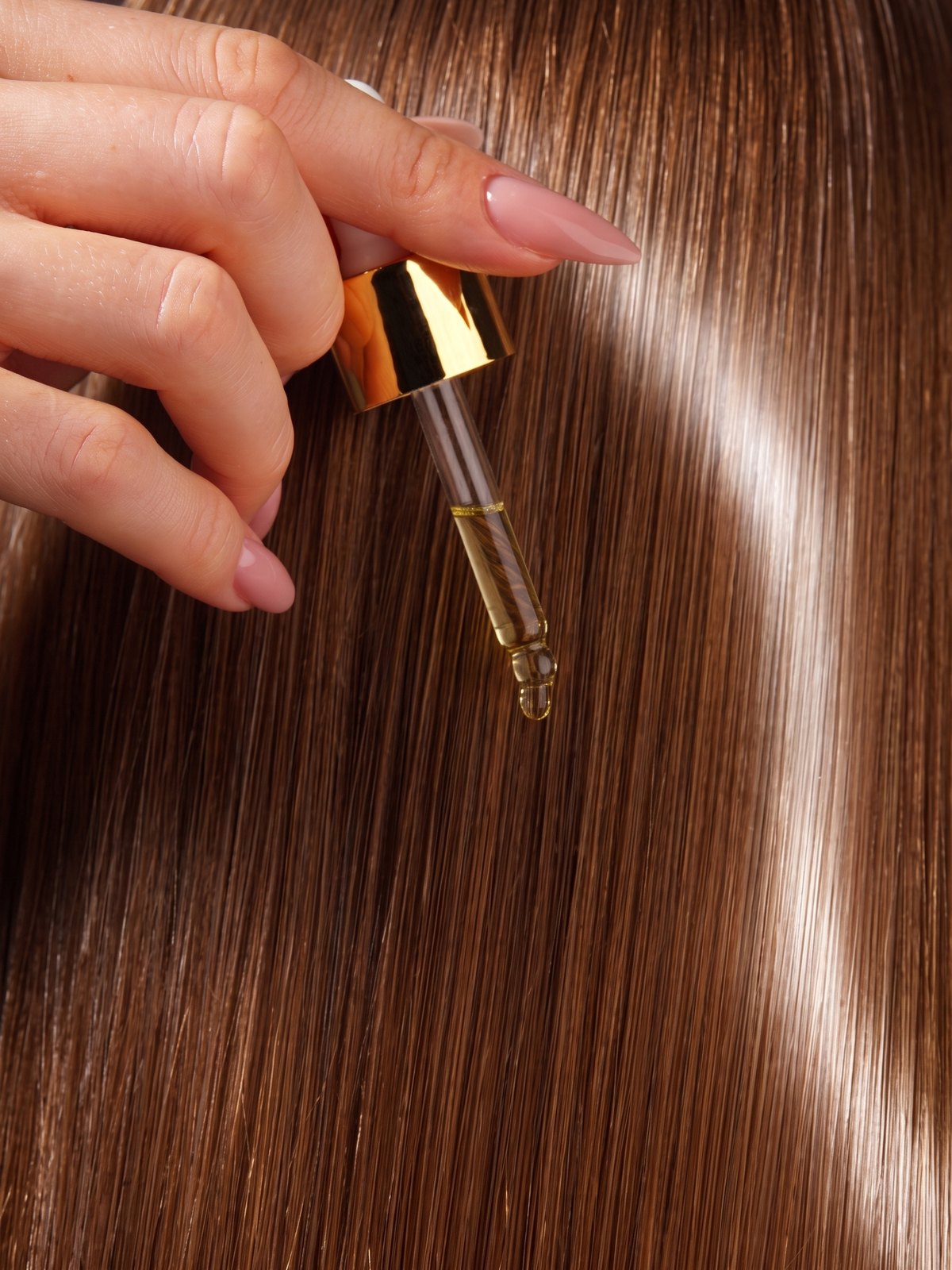 Golden elixir drop on hair